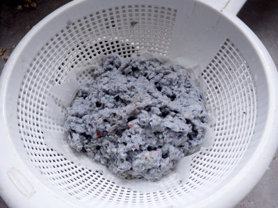 Paper pulp being strained through a coffee filter